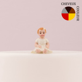 La figurine du bébé fille assis